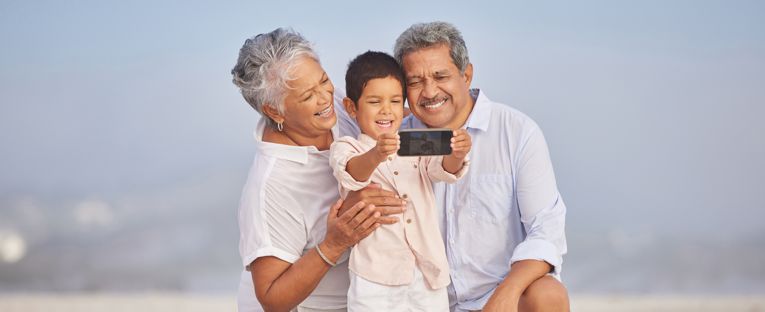 senior-couple-at-beach-with-grandson